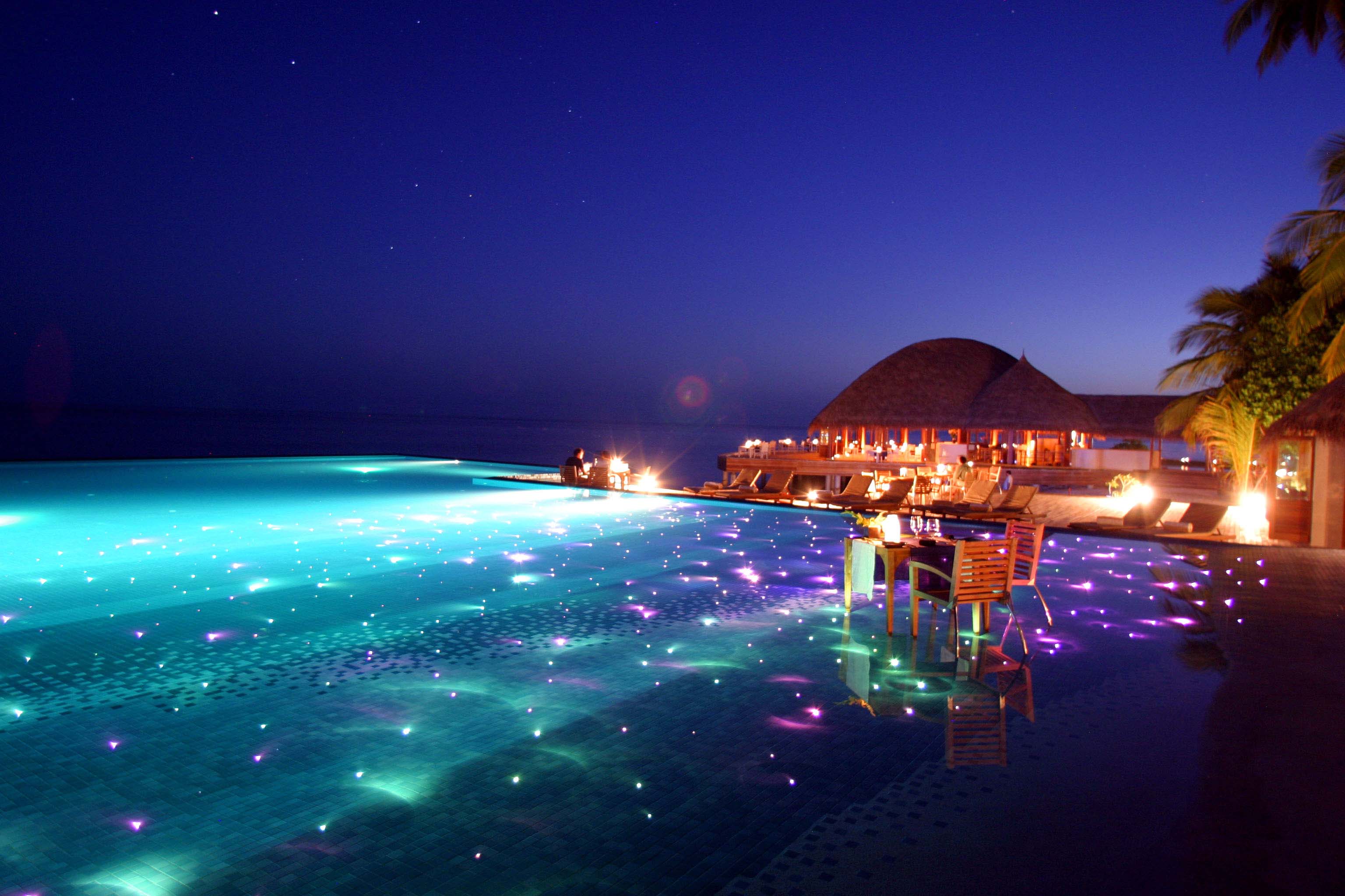 infinity pool with dining and led lights huvafen fushi resort in maldives