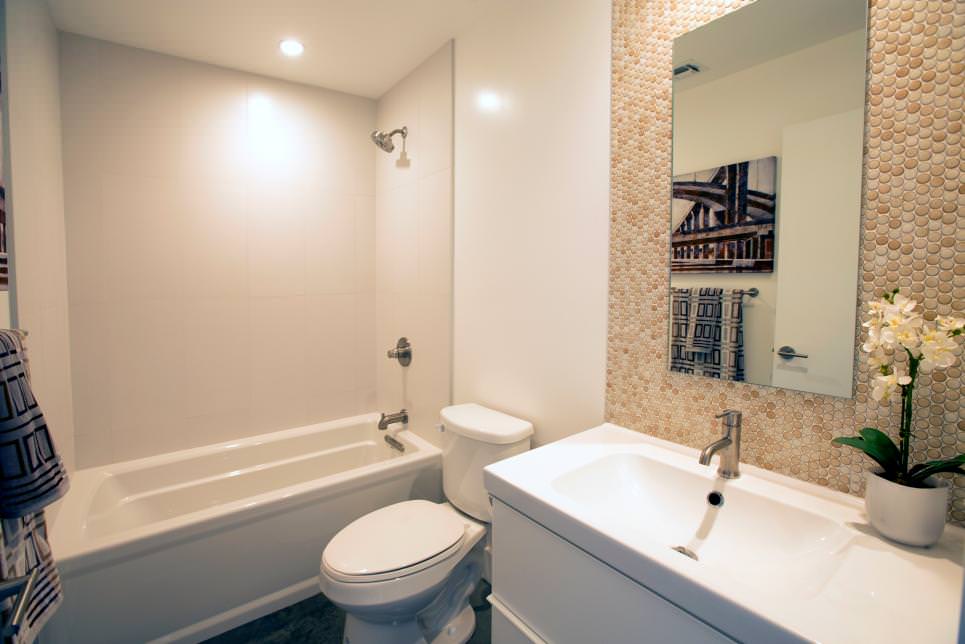 modern white bathroom with neutral pebble backsplash