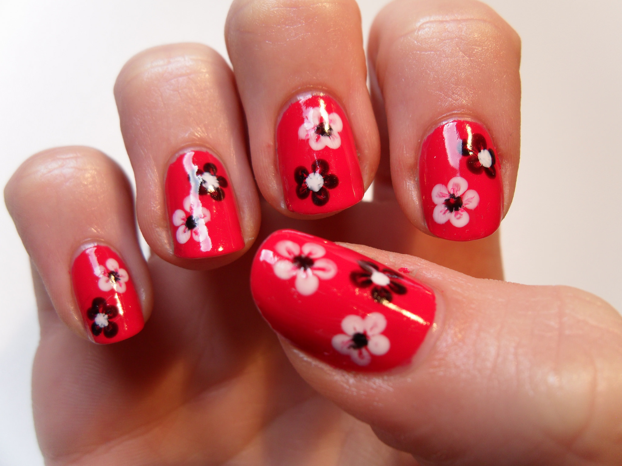 floral nail art on red nails