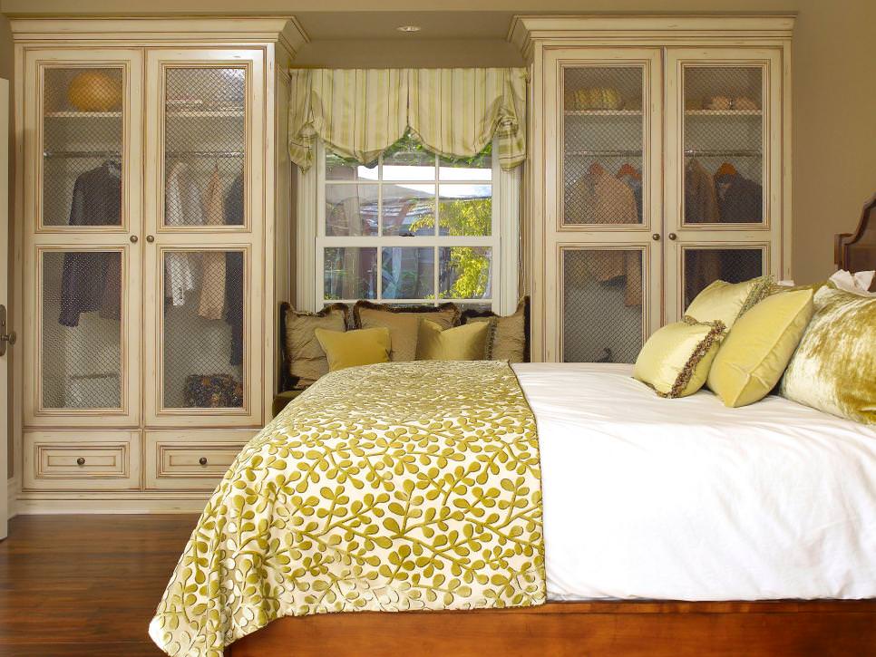 traditional yellow bedroom with glass front armoires