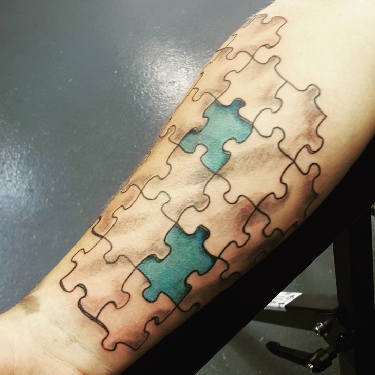 blue and black puzzle hand tattoo