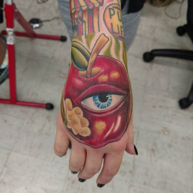 apple and eye tattoo on palm