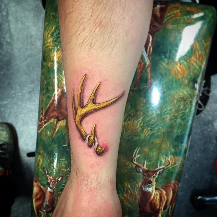 gold color single antler tattoo