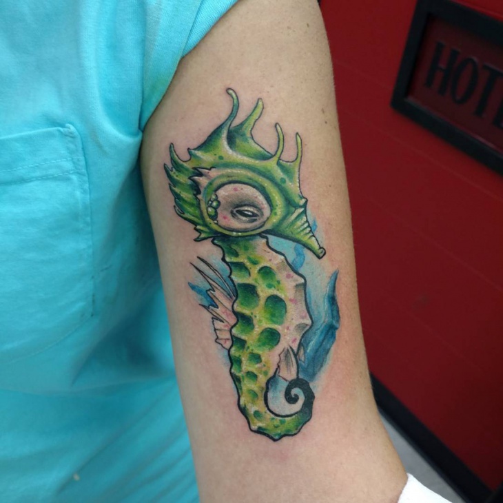green seahorse tattoo on hand