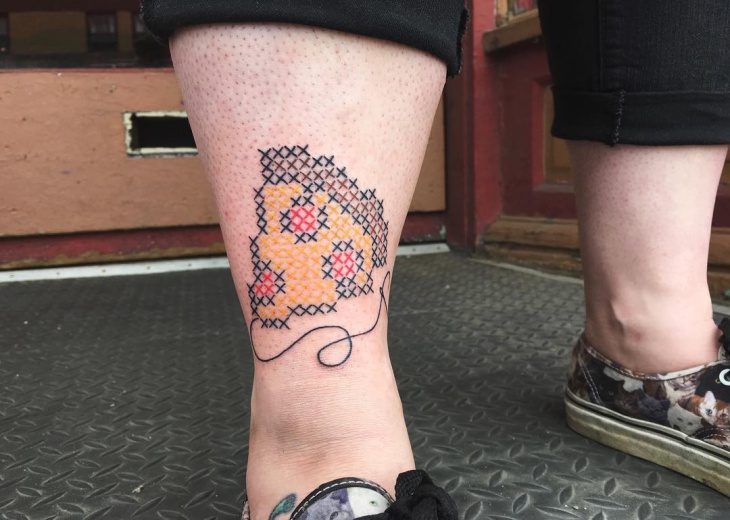 cross stitch tattoo on leg