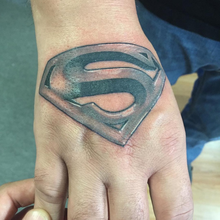 black and gray superman tattoo on palm