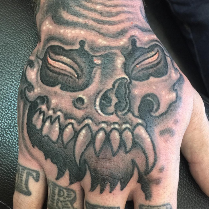 evil skull hand tattoo
