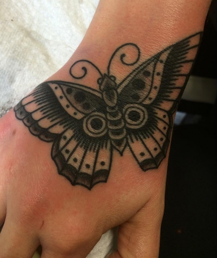 black butterfly tattoo on hand