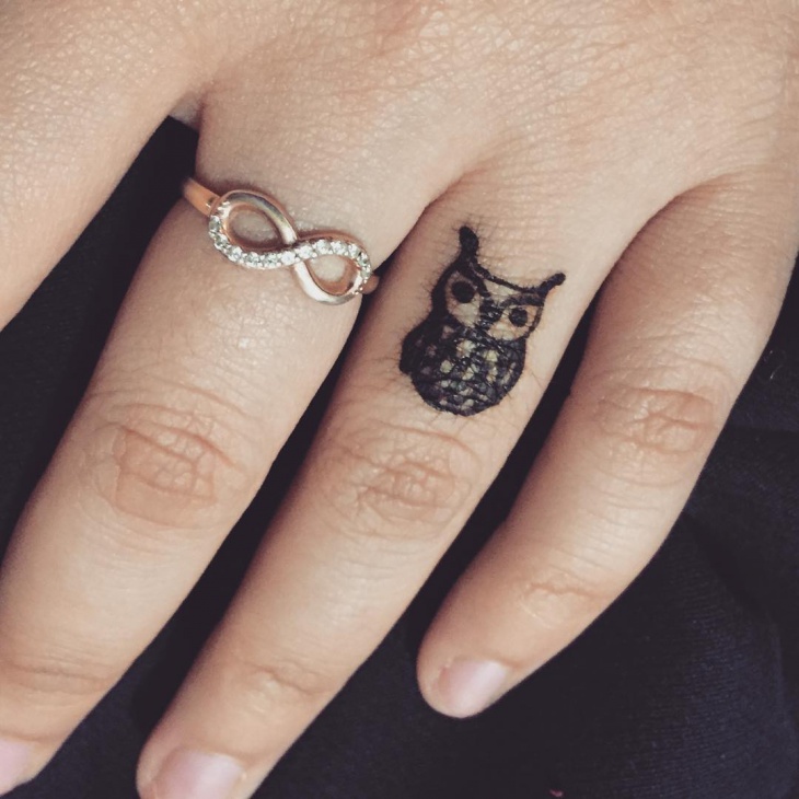 small owl tattoo on finger