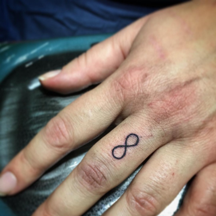 small infinity tattoo on finger