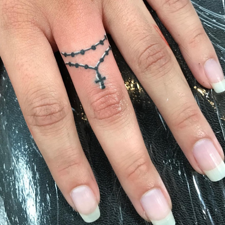 cross tattoo on middle finger