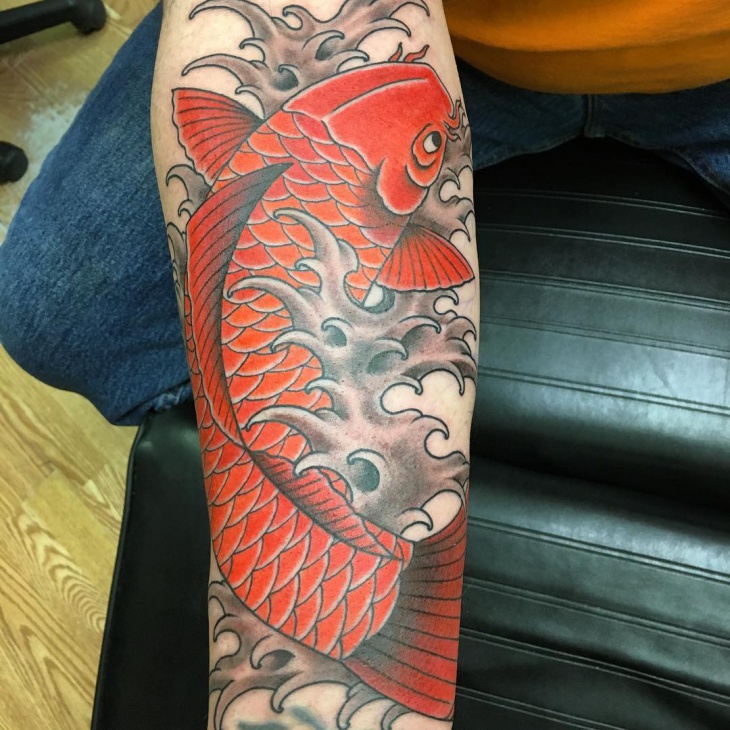 red koi fish tattoo on forearm