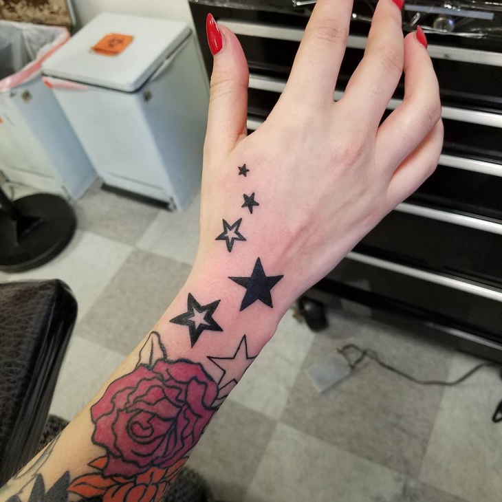 small star tattoo on palm