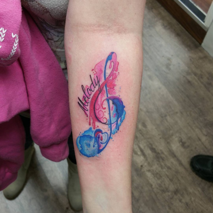 watercolor music tattoo on forearm