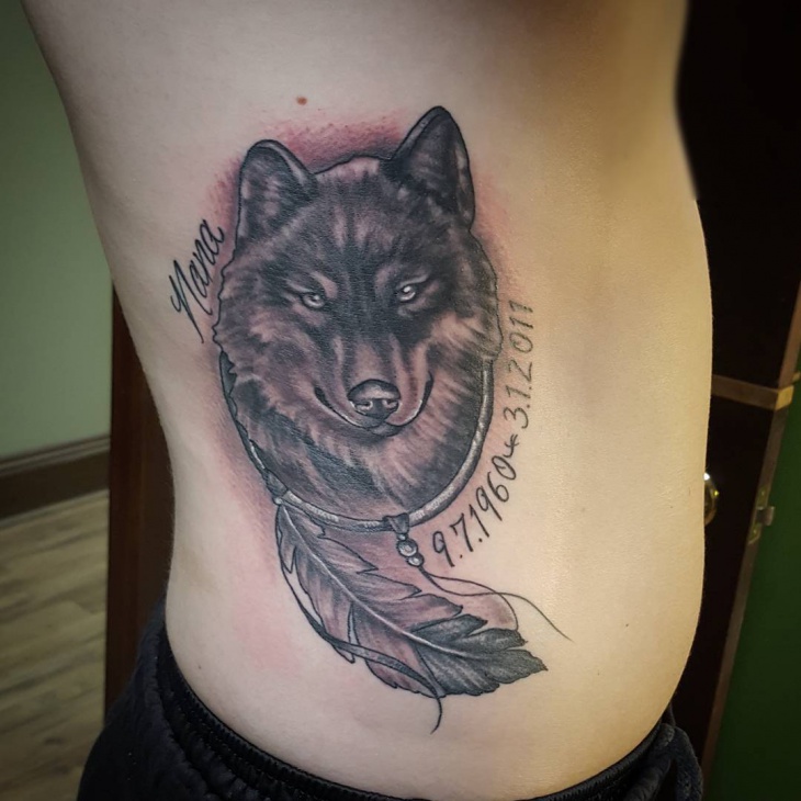 feather with wolf stomach tattoo